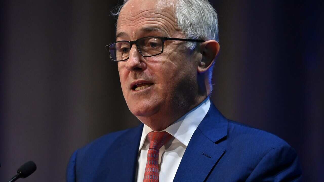 A man speaking at a microphone.