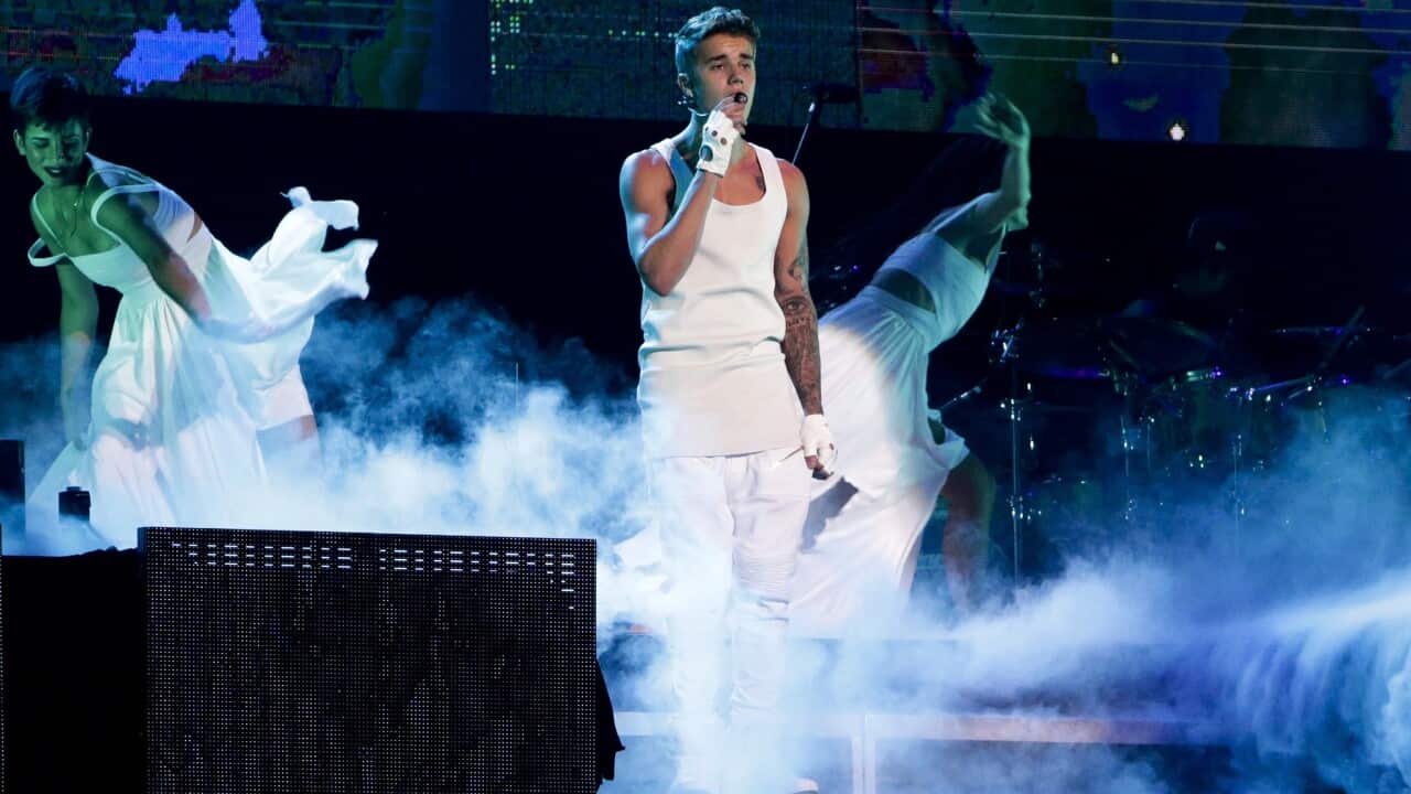 Justin Bieber, center, performs on a stage during his world tour concert in Beijing, China Sunday, Sept. 29, 2013.