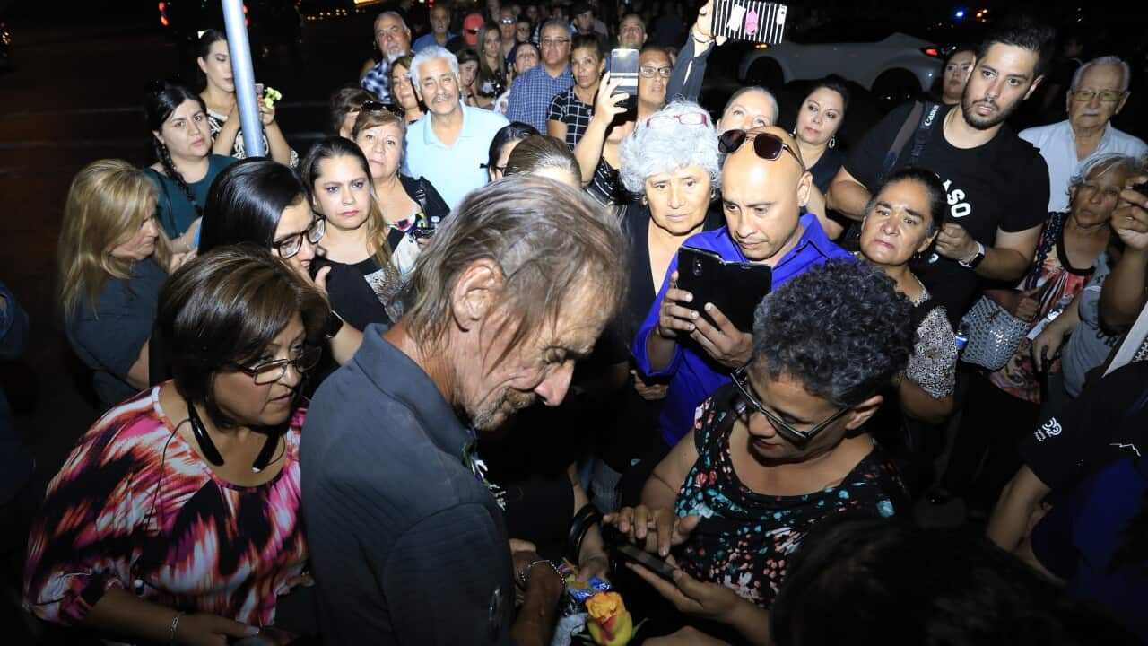 Antonio Bosco, husband of Margie Reckard who lost her life during a shooting, is offered condolences with flowers Friday, Aug. 16, 2019, in El Paso, Texas. Reckard was killed during the mass shooting on Aug. 3. (AP Photo/Jorge Salgado)