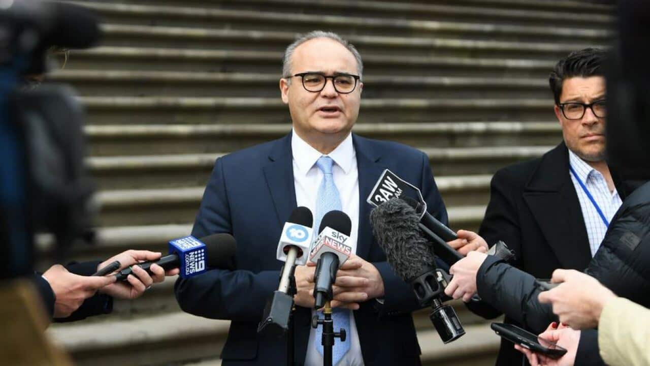 Adem Somyurek speaks to reporters on the steps of the State Parliament of Victoria