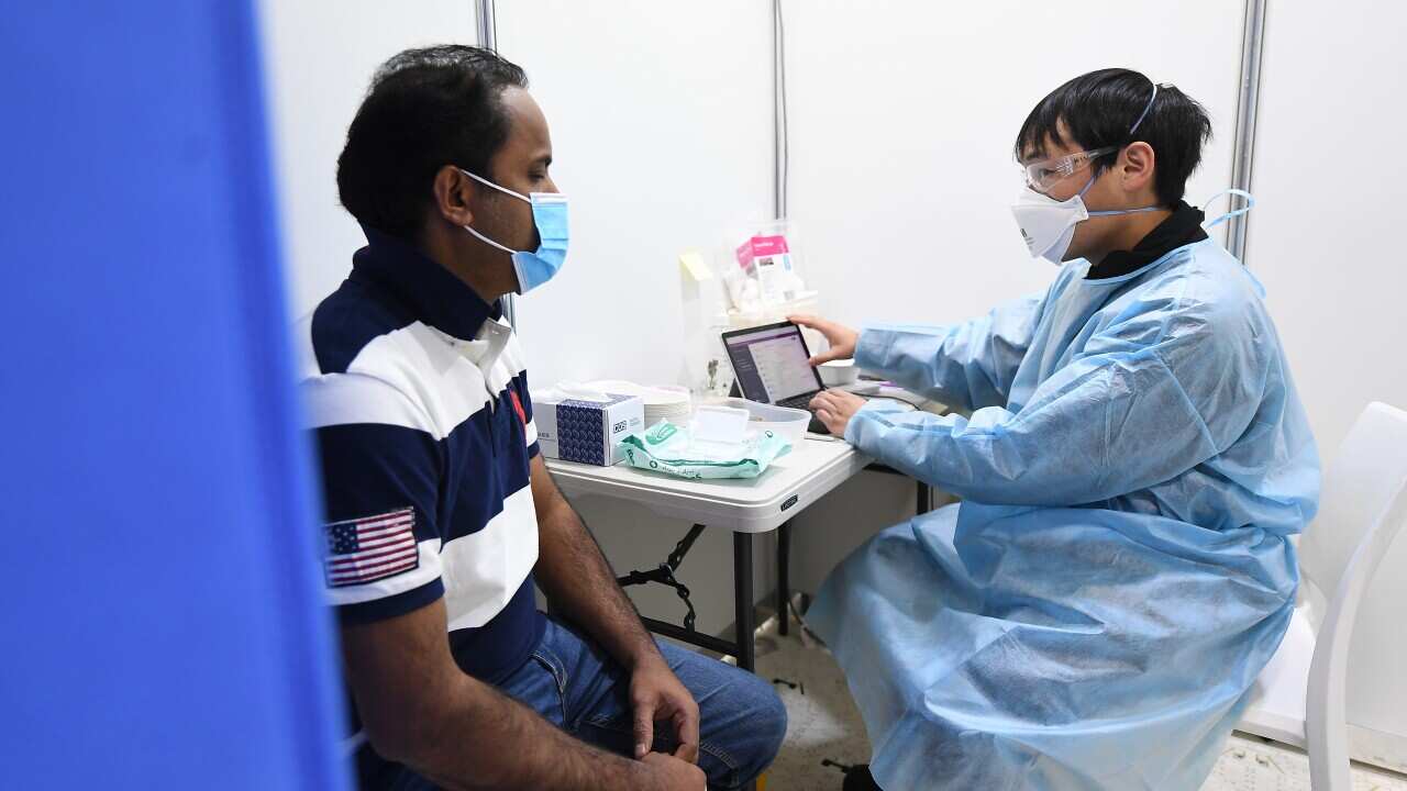 Rayees Mohammed (left) speaks with healthcare worker Chee Kin Lee prior to receiving his Covid19 vaccination at a pop-up Covid-19 vaccination clinic at the Australian Islamic Centre in Newport, Melbourne, Friday, September 10, 2021. (AAP Image/James Ross)