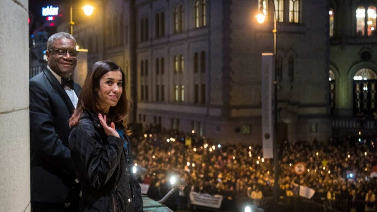 Nobel Peace Prize laureates Dr Denis Mukwege, left, and Nadia Murad watch the torchlight parade in Oslo, Norway