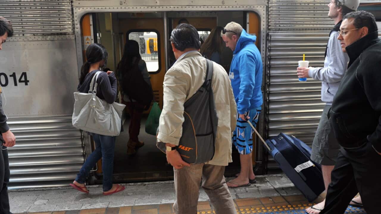 Commuters board a train at a station in Sydney