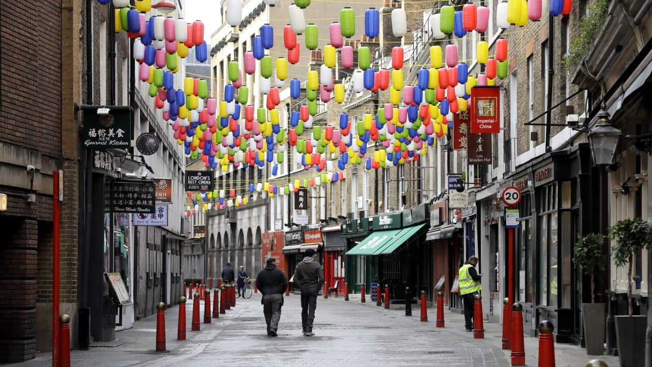 People walk through a quiet Chinatown in London, Wednesday, Jan. 6, 2021.
