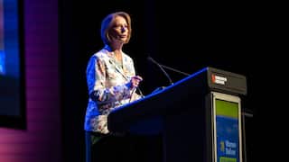 Julia Gillard stands behind a lecturn