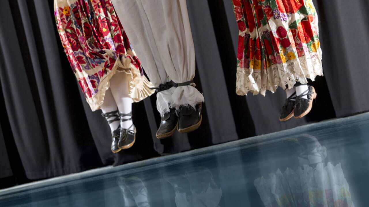 Traditional Croatian Folklore Dancers in action, short depth of field, reflection on blue floor