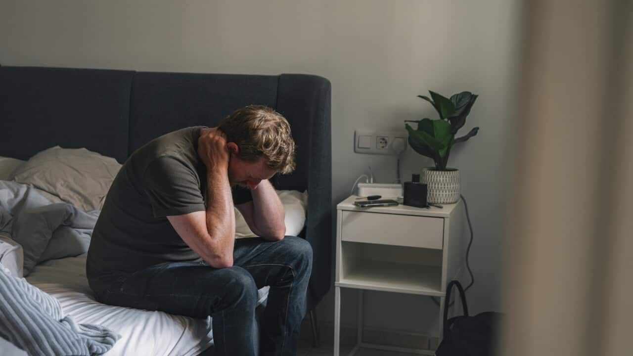 Mature male sitting on his bed - negative emotion