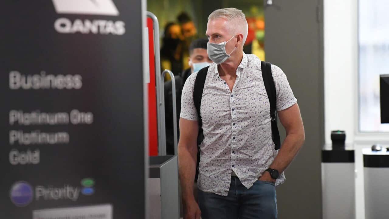 People wearing face masks are seen disembarking flight QF401 from Sydney at Melbourne Airport in Melbourne,