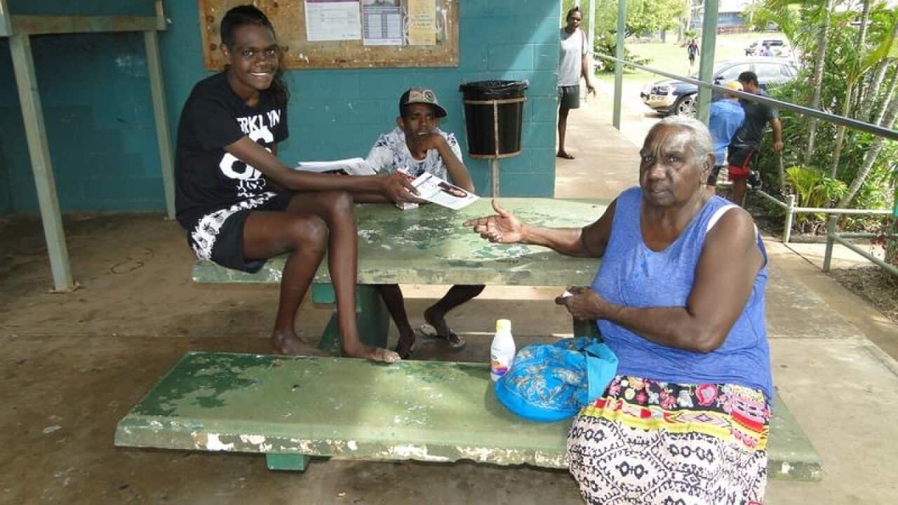 Locals residents hand out how to vote cards in the town of Naiyu.
