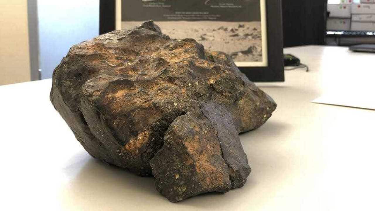A 12-pound (5.5 kilogram) lunar meteorite discovered in Northwest Africa in 2017 rests on a table, in Amherst, N.H.