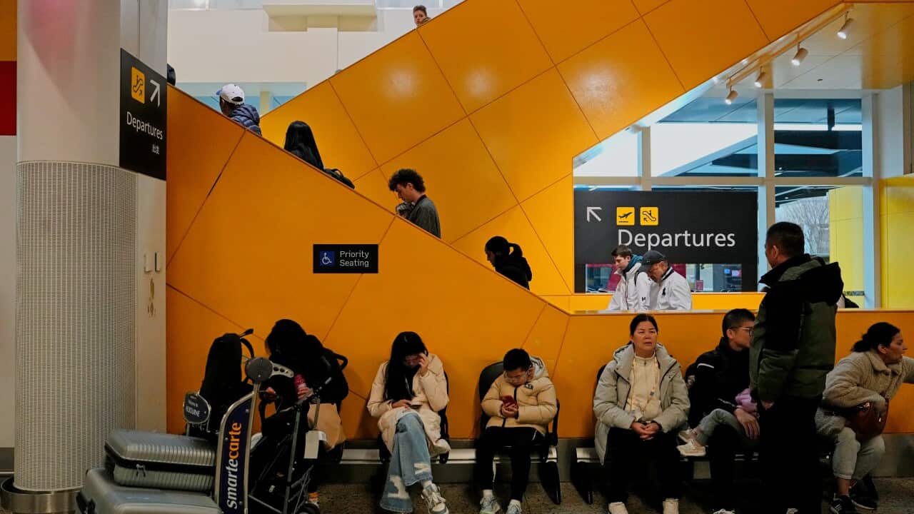 A crowd of people sit in an airport