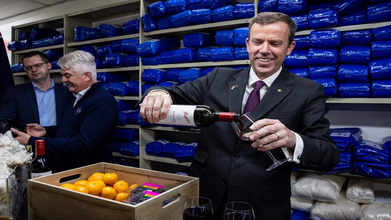 Minister for Trade, Tourism and Investment Dan Tehan pours wine in a glass during a press conference about the signing of the trade agreement with India, in Melbourne, Saturday, April 2, 2022. (AAP Image/Diego Fedele) NO ARCHIVING
