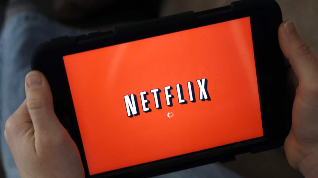 A person displays Netflix on a tablet