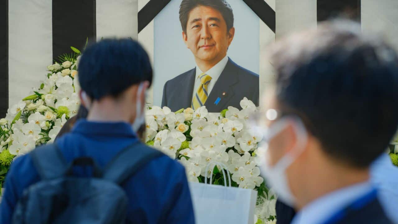 People are seen leaving flowers and paying their respects during the state funeral for Japan's former prime minister Shinzo Abe.