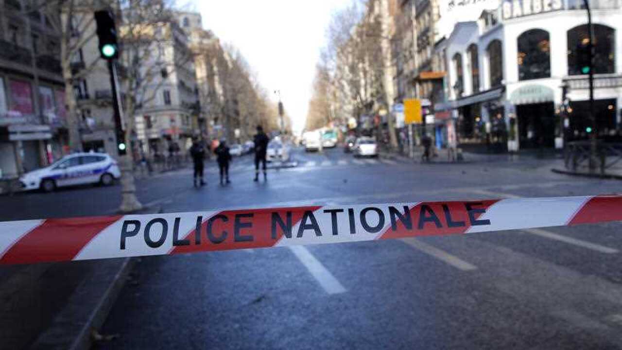 Police officers cordon off the area of a fatal shooting which took place at a police station in Paris.