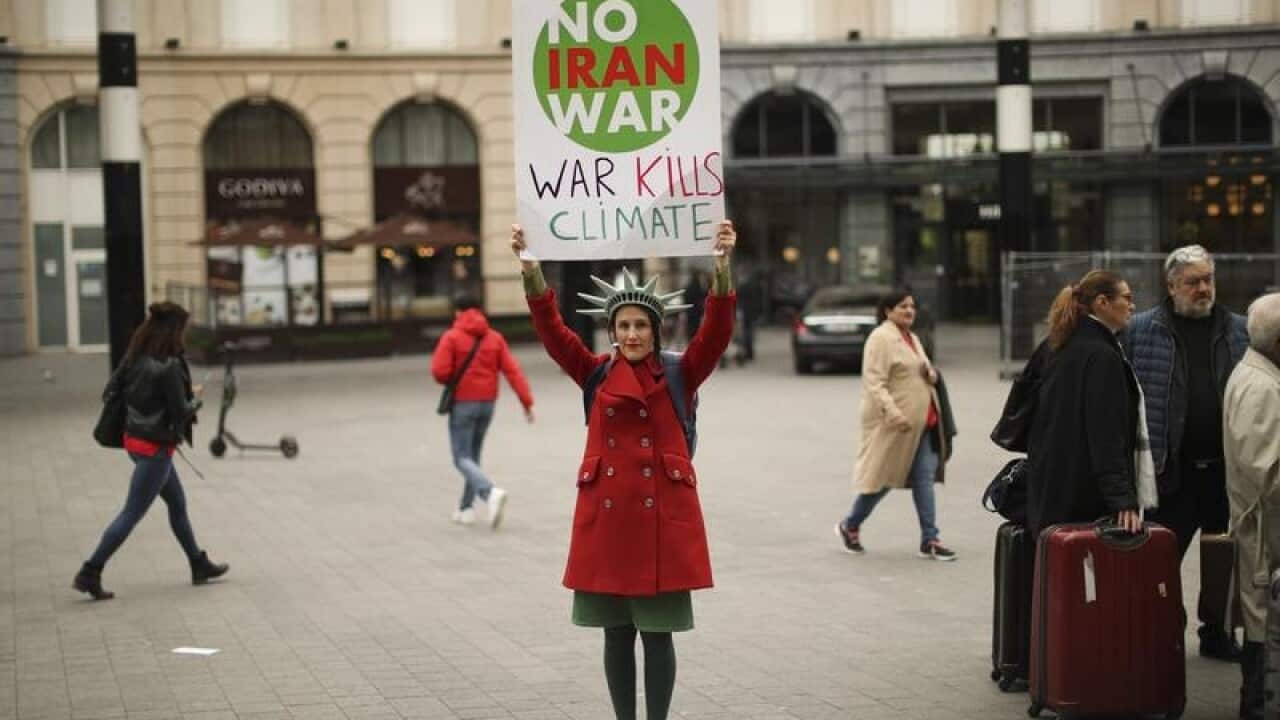 A woman holds up a banner in Brussels as the EU meets