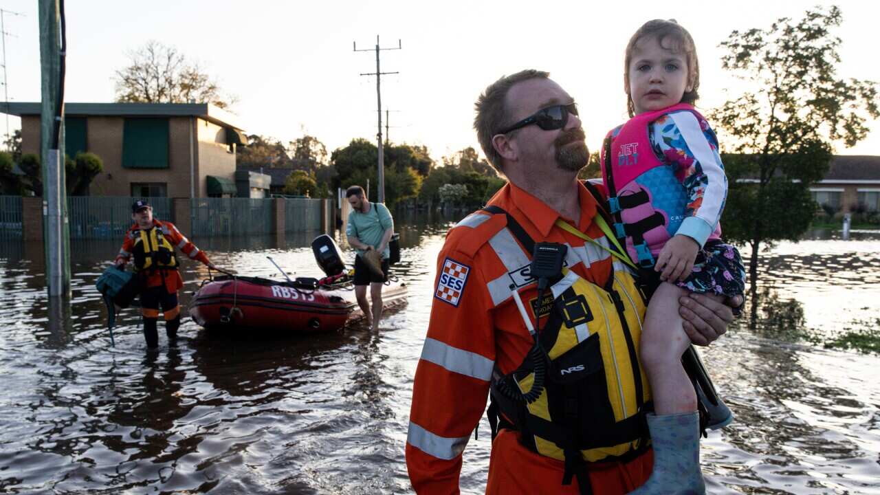 SES personnel help a family leaving their home in Shepparton, Victoria, Sunday, October 16, 2022.