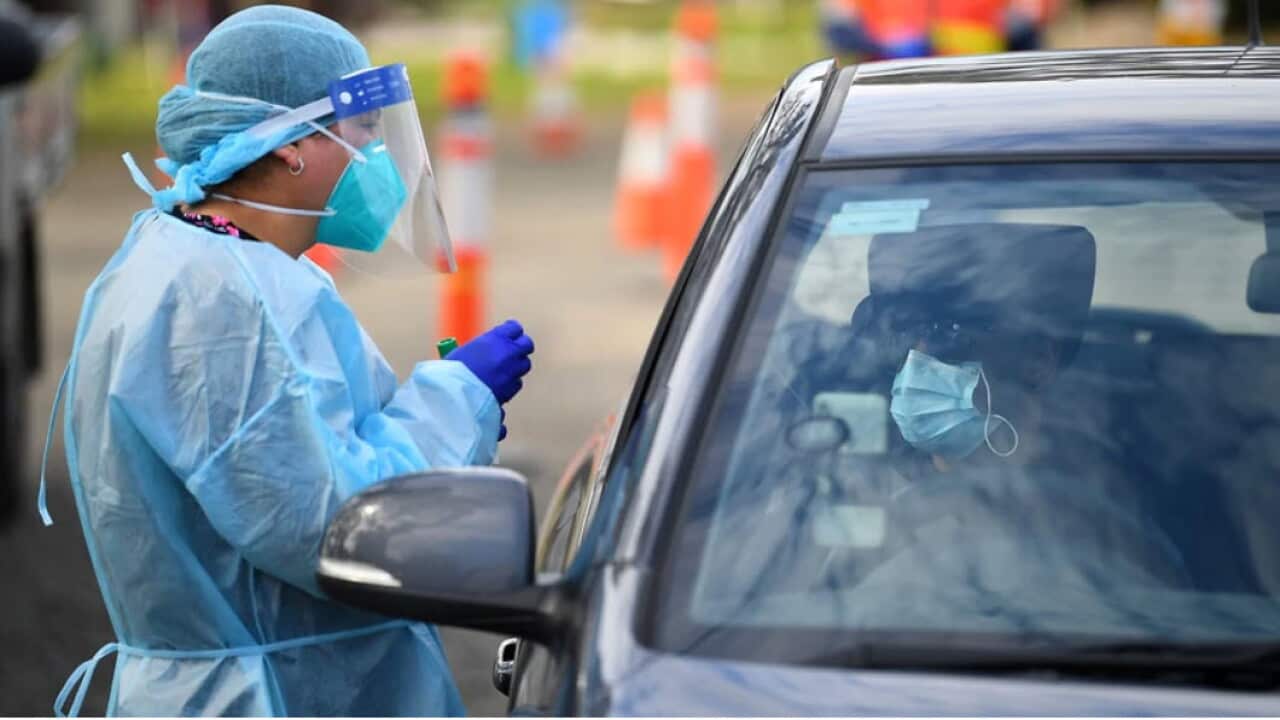 Healthcare workers are seen at a drive through pop up coronavirus testing facitlity in Melbourne.