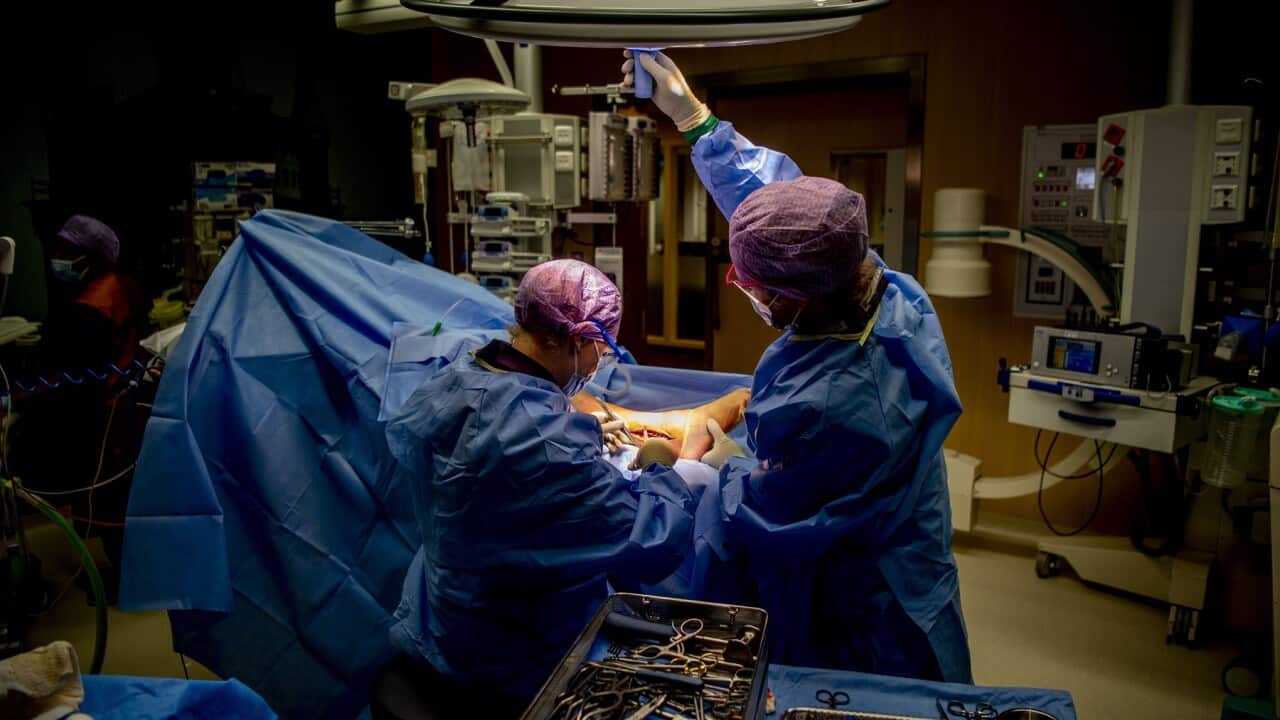 Doctors doing an operation on a broken leg in the surgery
