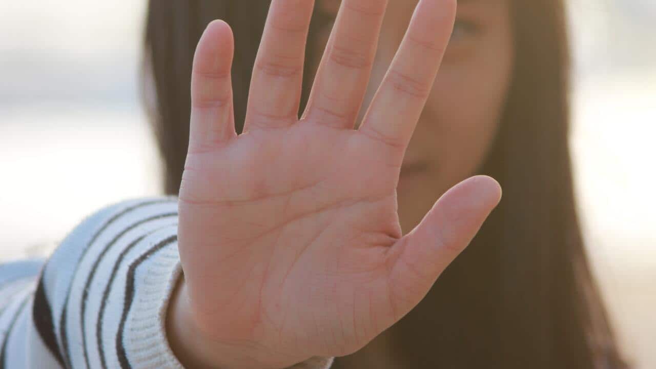 ผู้หญิงยกมือขึ้นปิดหน้า