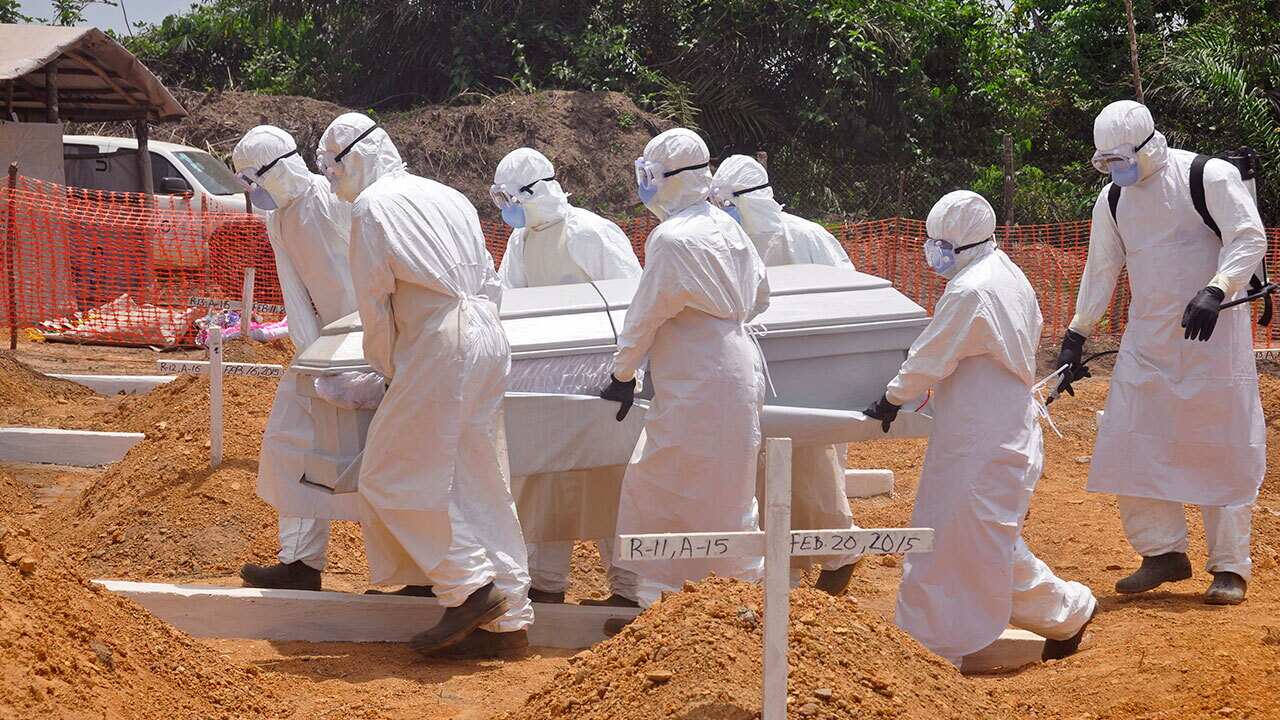 In this file photo, health workers carry a body of a person that they suspected died form the Ebola virus at a graveyard outside Monrovia, Liberia.