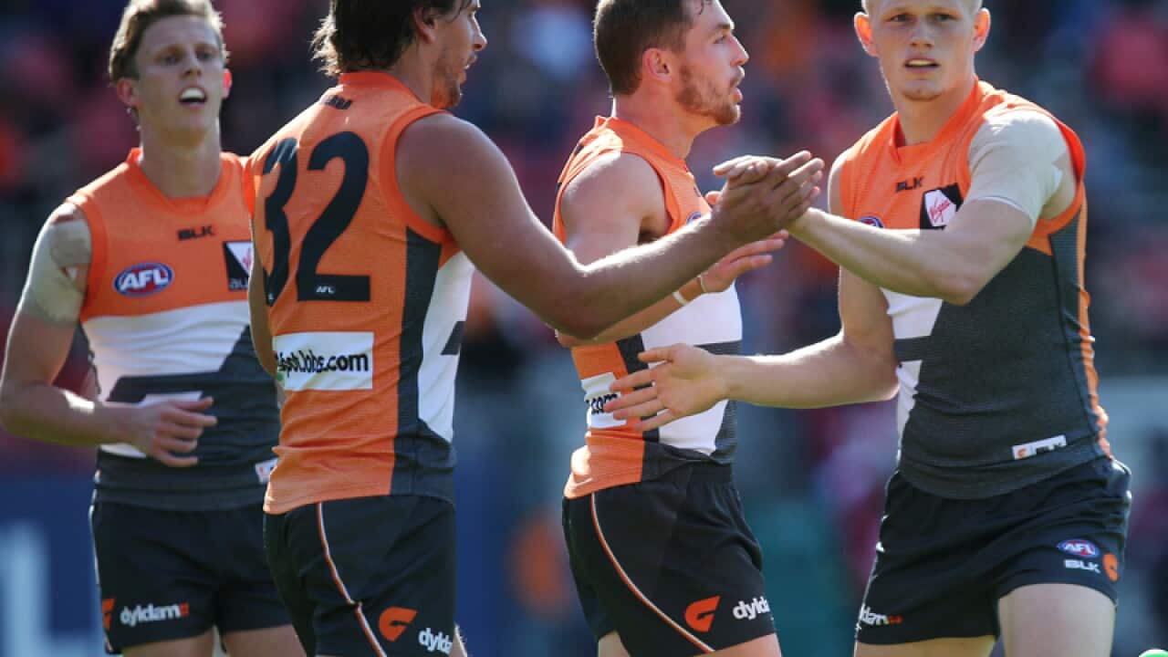 Giants' Adam Treloar (right) celebrates.