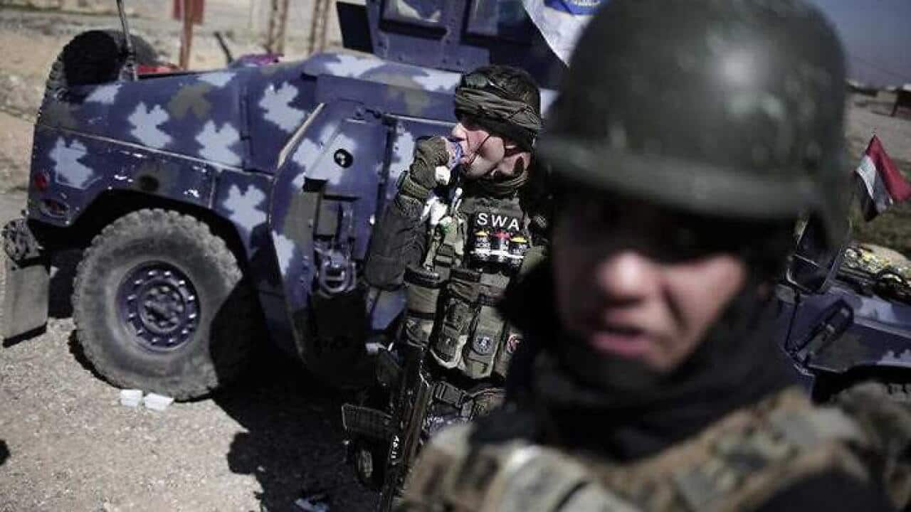 A member of the federal police takes a break from fighting Islamic State militants, in Hamam al-Alil