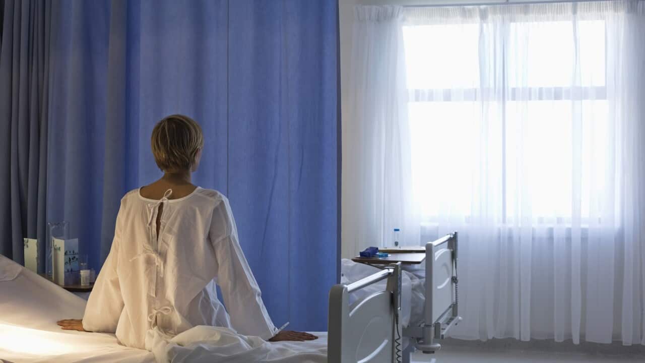 Patient wearing gown on hospital bed