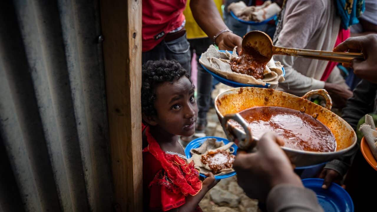 People receive food donated by local residents at a reception centre for the internally displaced in Mekele, in the Tigray region of northern Ethiopia