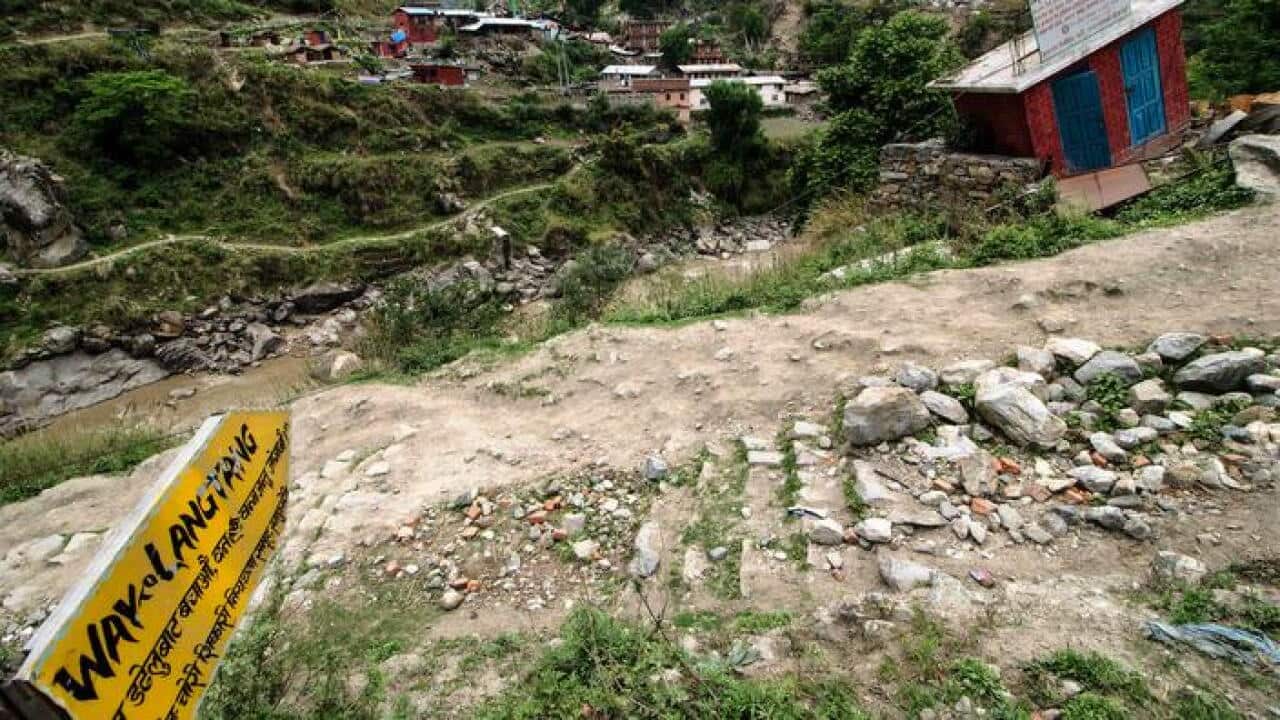 A sign shows the start of the Langtang Trail, Nepal, the day after a massive earthquake hit the region