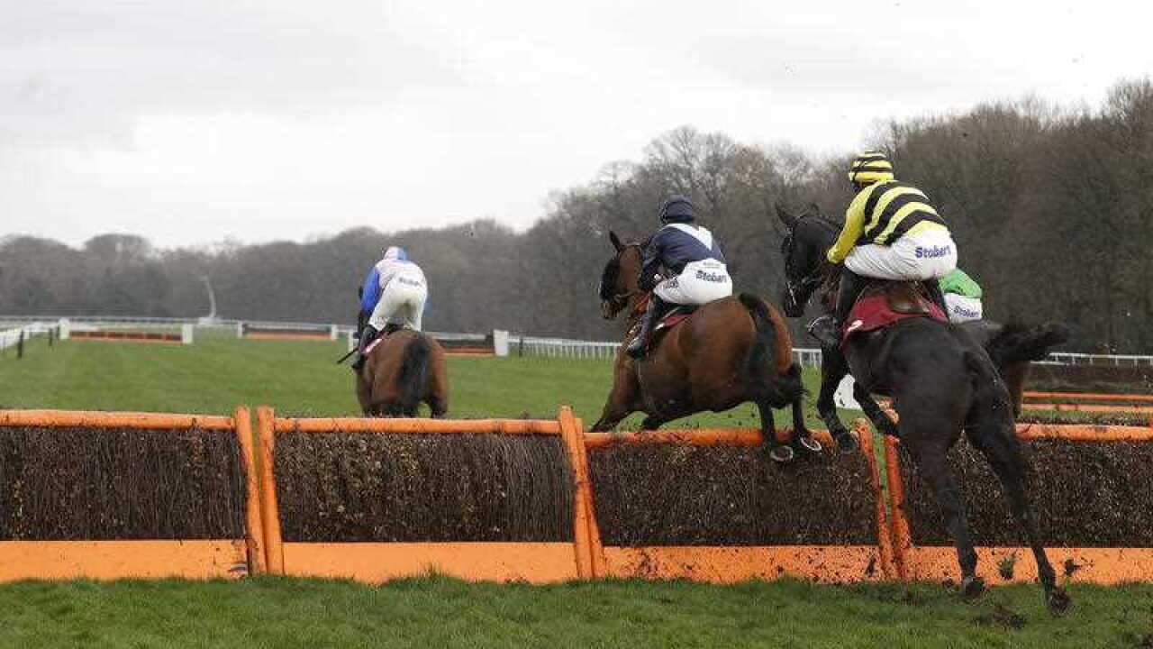 Horses jump a hurdle during The Howdens Joinery Hanicap Hurdle Race,at Haydock Racecourse.