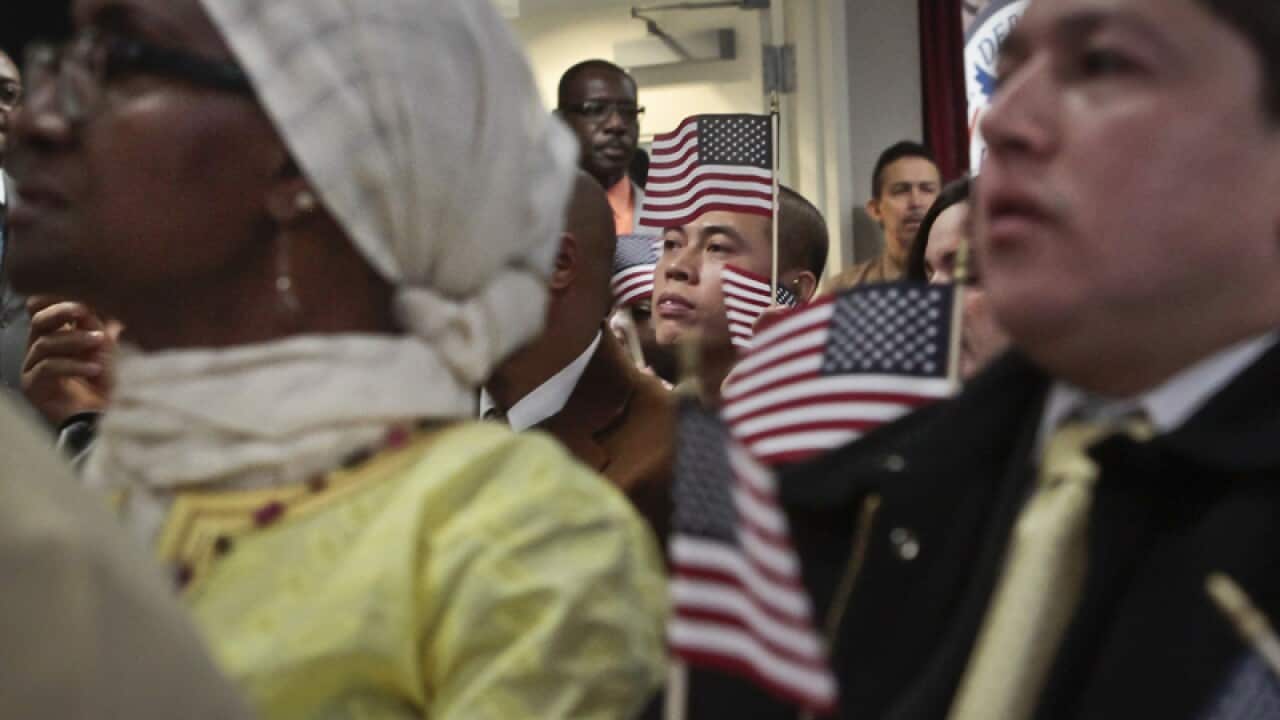 Immigrants hold miniature US flags during a naturalisation ceremony