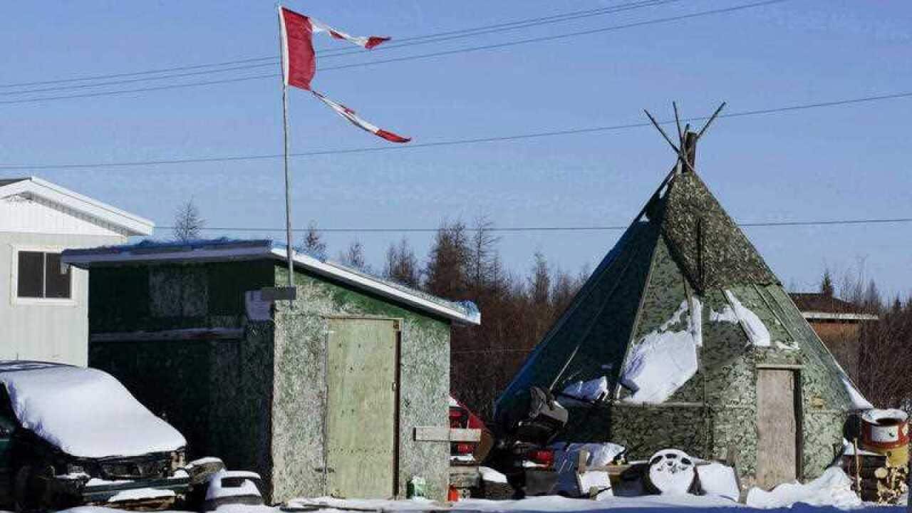 In this Nov. 29, 2011 photo, a tattered Canadian flag flies over a building in Attawapiskat, Ontario, Canada.