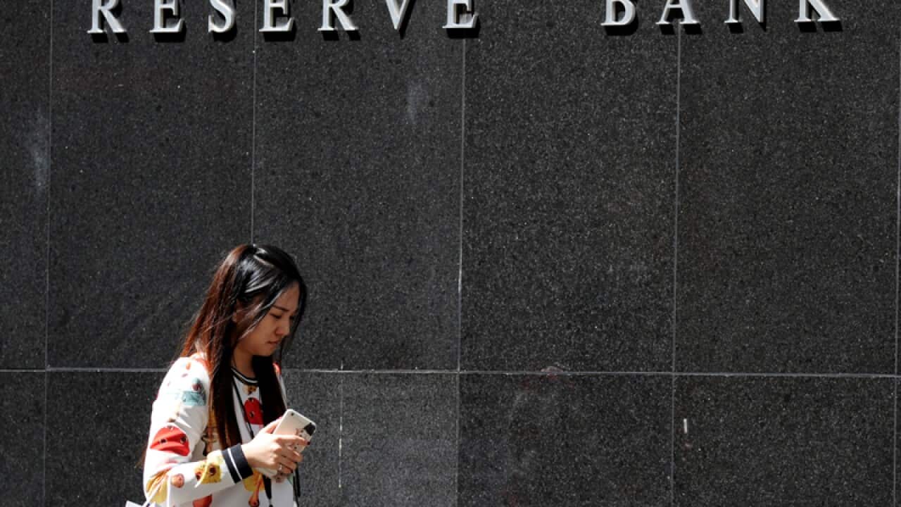 Pedestrians walk past the Reserve Bank of Australia (RBA)