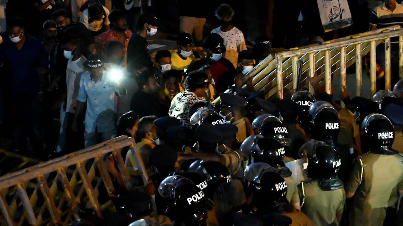 Anti-riot police officers are seen attempting to block protesters.