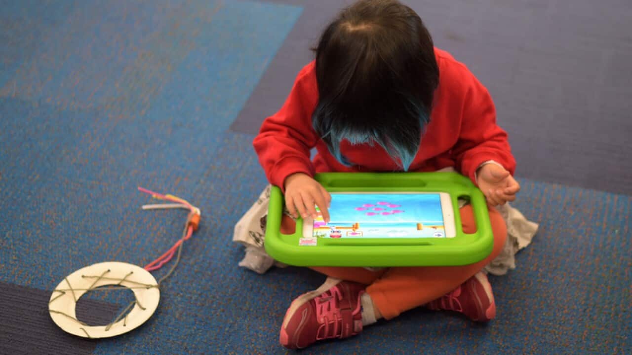 A girl plays on an iPad at Franklin Early Learning School in Canberra
