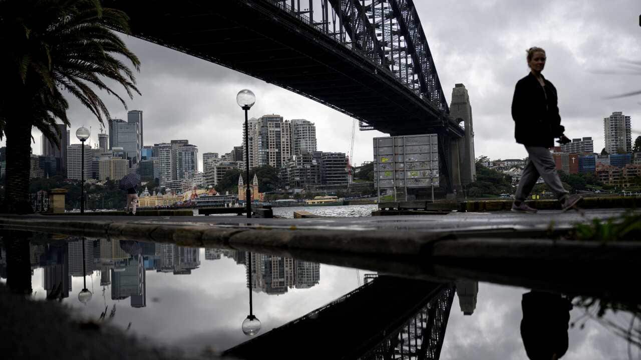 The Harbour Bridge is seen as people walk by in Sydney,