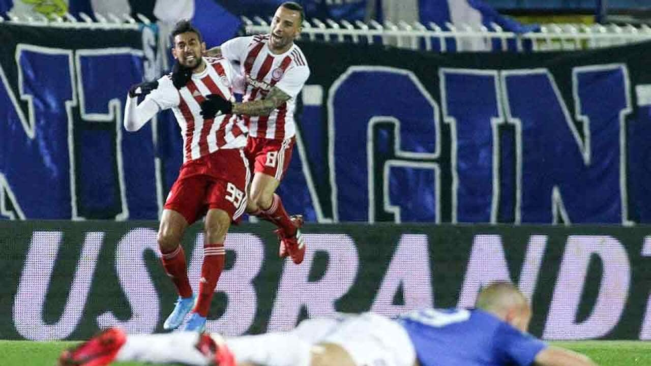 Olympiacos' Ahmed Hassan (left) celebrates his late winner against Atromitos