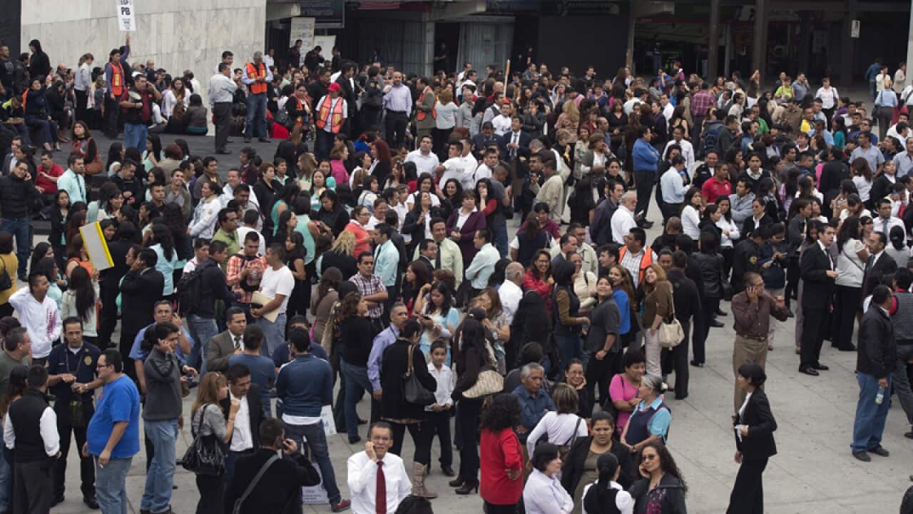 People wait in a street after a strong earthquake in Mexico City