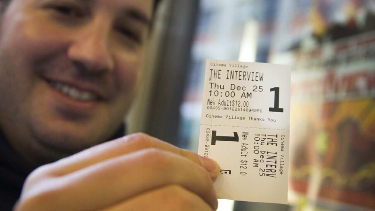 A man holds his ticket to a screening of The Interview