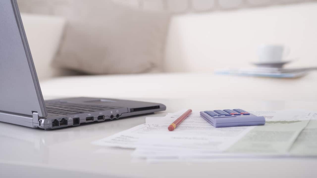 Laptop and paperwork on office table (AAP)