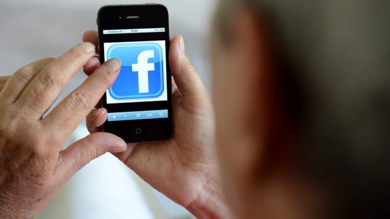 An older woman using Facebook on her phone