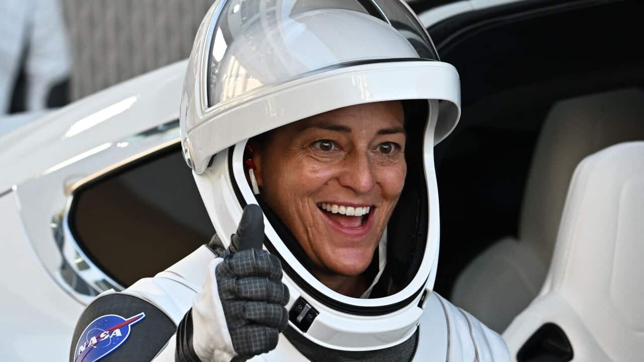 astronaut nicole man gives a thumbs up and a smile from within her sleek white and black nasa space suit.
