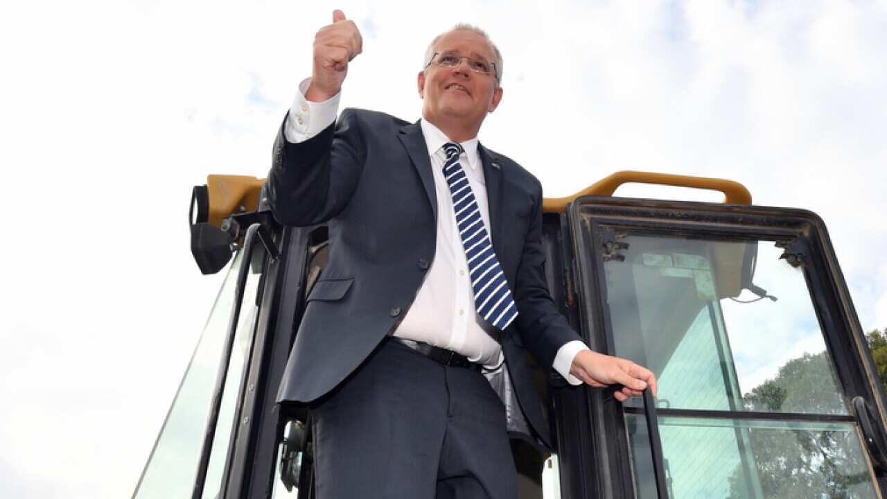 Prime Minister Scott Morrison climbs out of the cabin of a loader during a visit to the landscaping business of Daisy's at Ringwood in Melbourne, Monday, April 15, 2019. (AAP Image/Mick Tsikas) NO ARCHIVING