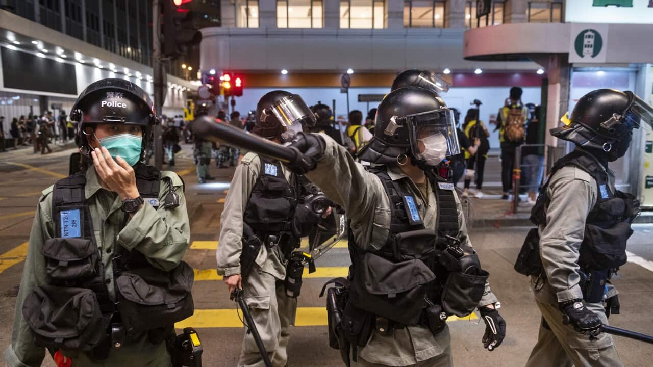 A police officer gestures with his baton in Hong Kong