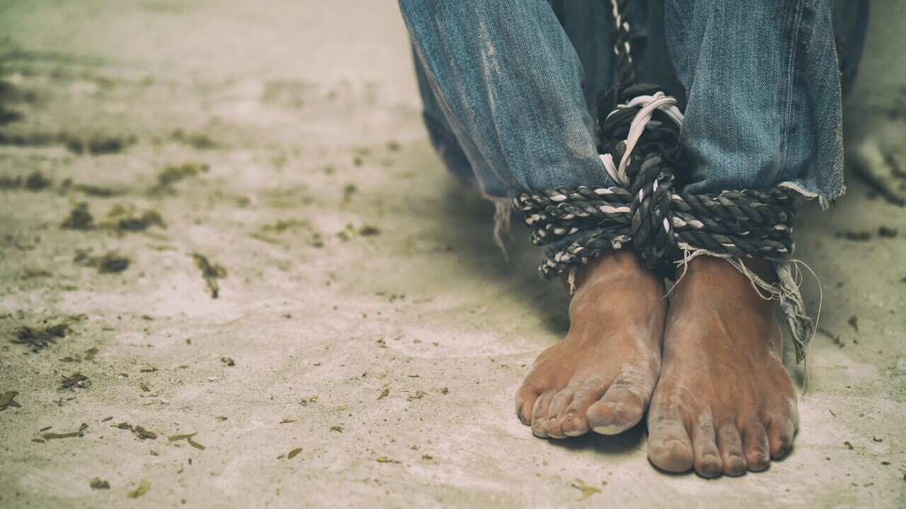 A man's feet tied together with rope