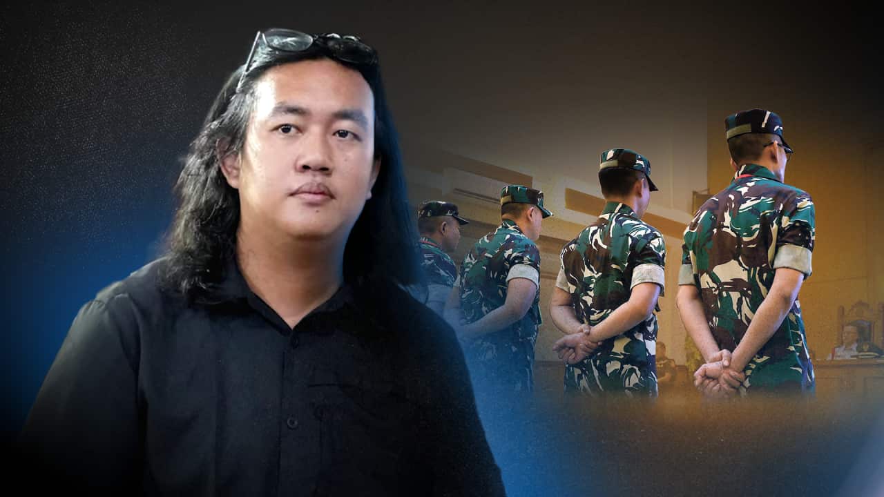 A stylised image shows a long-haired man in a black shirt, positioned left of centre, with four uniformed soldiers in the background to the right, standing in a courtroom with their backs to the viewer and hands clasped behind them.