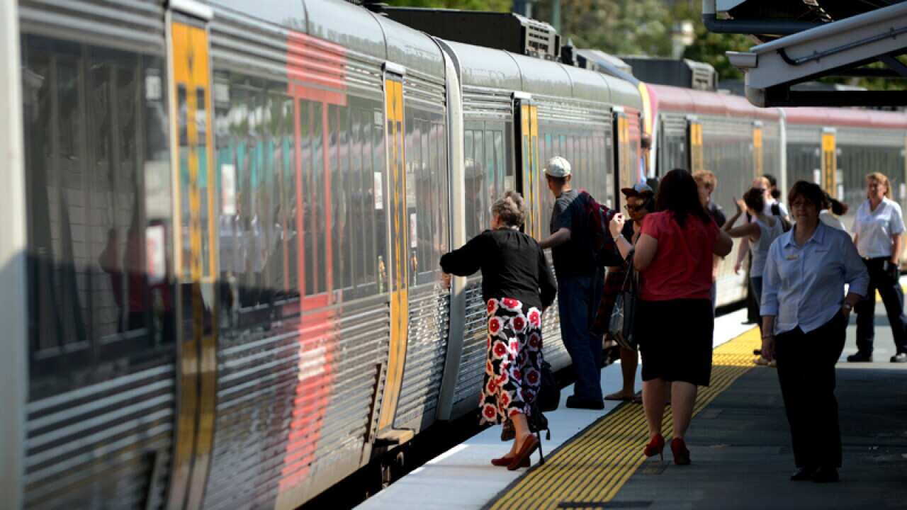 Passengers board a Queensland Rail (QR) train
