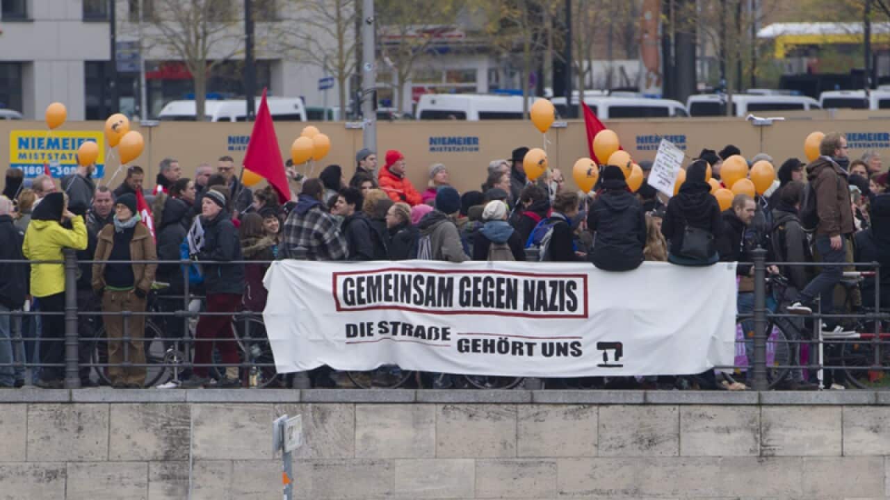 Counter-demonstrators hold a banner with words Gemeinsam gegen Nazis