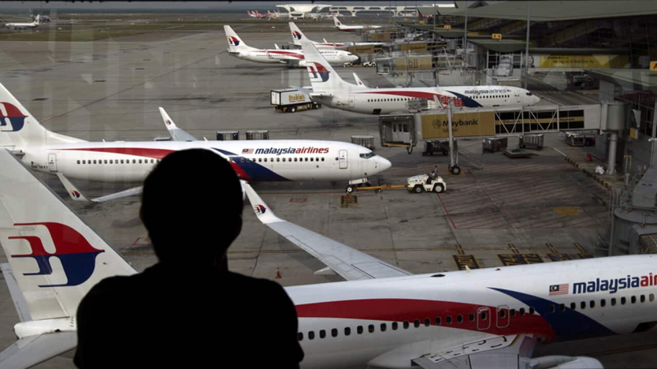 (FILE) A passenger looks from a window at Malaysia Airlines aircraft
